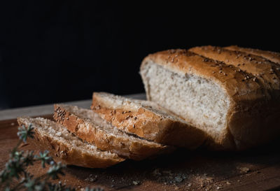 Close-up of bread on cutting board against black background