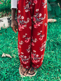 Low section of woman standing on field