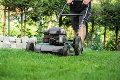 Low section of man mowing lawn
