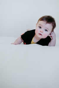 Portrait of cute girl lying down on bed at home