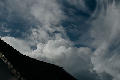 Low angle view of buildings against cloudy sky