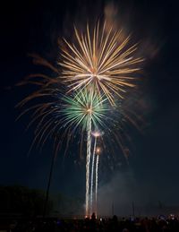 Low angle view of firework display at night