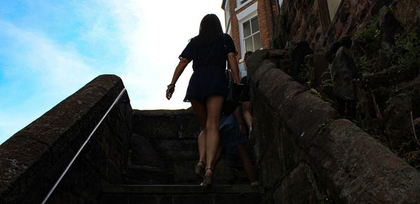 Rear view of woman walking on staircase