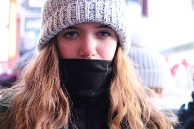 Close-up portrait of teenage girl wearing warm clothing in city