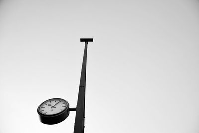Low angle view of clock on pole against clear sky at dortmund hauptbahnhof