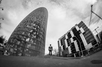 Rear view of man standing in front of buildings in city