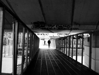 Rear view of woman walking on footpath amidst buildings