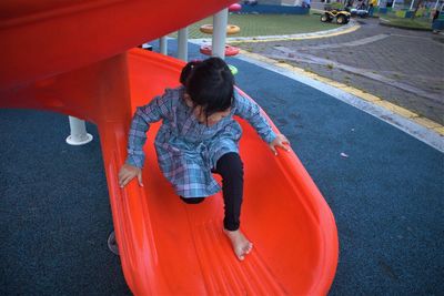 Rear view of boy playing on playground