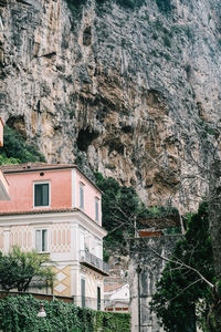 Low angle view of buildings against rocky mountains