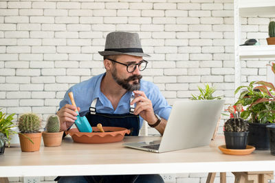 Portrait of senior man using mobile phone while sitting on table