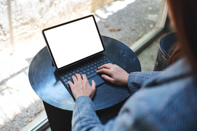 Midsection of woman using digital tablet