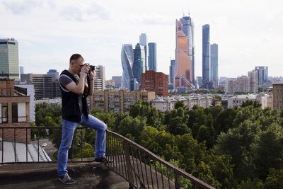 Man photographing buildings in city