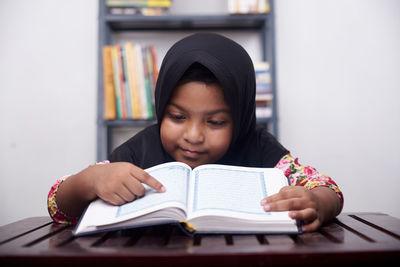 Cute muslim little girl reading koran