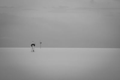 Man standing in sea against sky