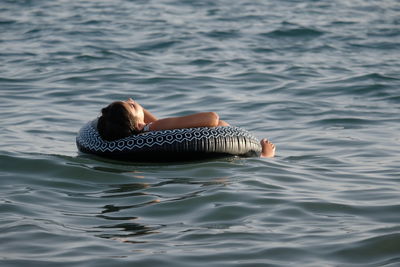 Rear view of woman swimming in sea