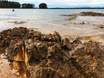 Rock formation on beach against sky