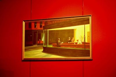 Reflection of illuminated window on red wall