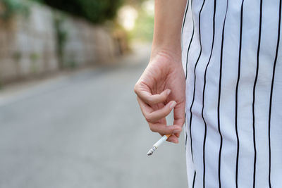 Close-up of hand holding cigarette