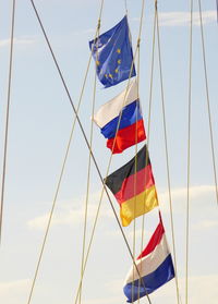 Low angle view of national flags on rope against sky