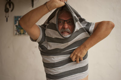 Portrait of man wearing hat standing at home