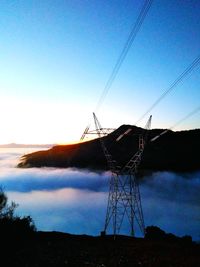 Low angle view of electricity pylon on land against sky