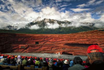 People on mountain range against sky