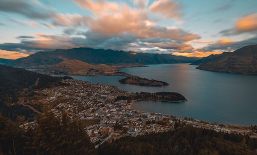 Aerial view of city by sea against sky