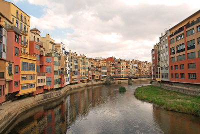 River amidst buildings in town against sky