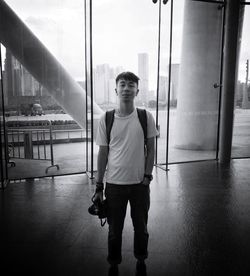 Portrait of young man standing against wall