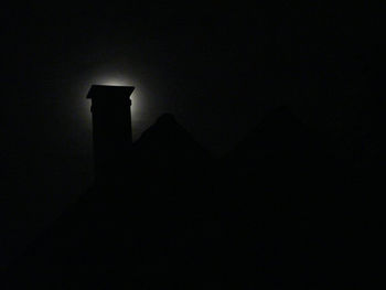 Low angle view of silhouette building against sky at night