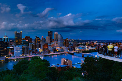 High angle view of city buildings against cloudy sky