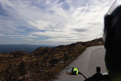 Man on road by mountain against sky