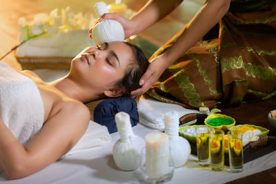 Woman giving forehead massage to customer in spa