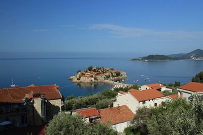 High angle view of town by sea against sky