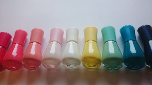 High angle view of colorful nail polishes arranged on white table