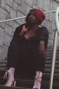 Young woman looking down while sitting on staircase