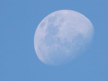 Low angle view of moon against blue sky