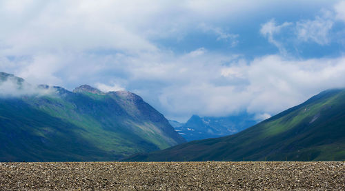 Scenic view of field and mountains against sky