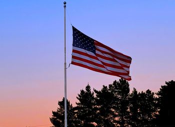 Low angle view of flag against sky at sunset