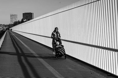 Rear view of man walking on bridge