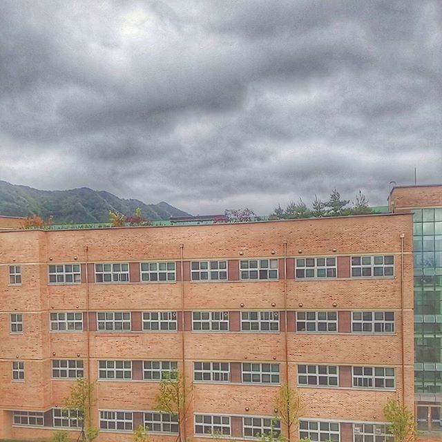 LOW ANGLE VIEW OF RESIDENTIAL BUILDINGS AGAINST CLOUDY SKY