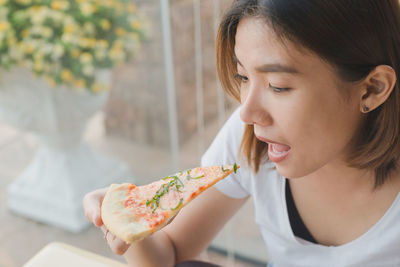 Close-up of woman eating pizza