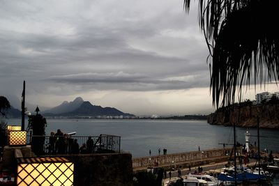 View of boats in sea against cloudy sky