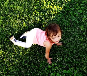 High angle view of cute girl crawling on grassy field