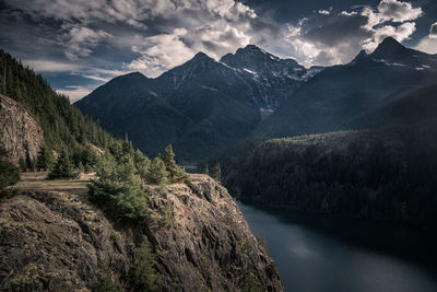 Scenic view of river by mountains against sky