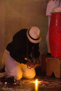 Midsection of woman standing against illuminated wall