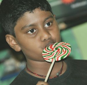 Close-up of thoughtful boy eating lollipop