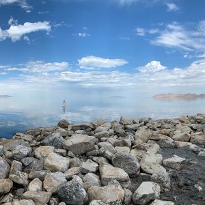 Rocks by sea against sky