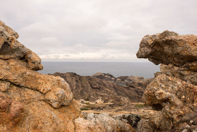 Scenic view of rock formation and sea against sky