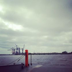 View of harbor against cloudy sky